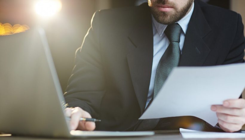 empresario-barbudo-trabalhando-com-documentos-no-escritorio_1098-16040